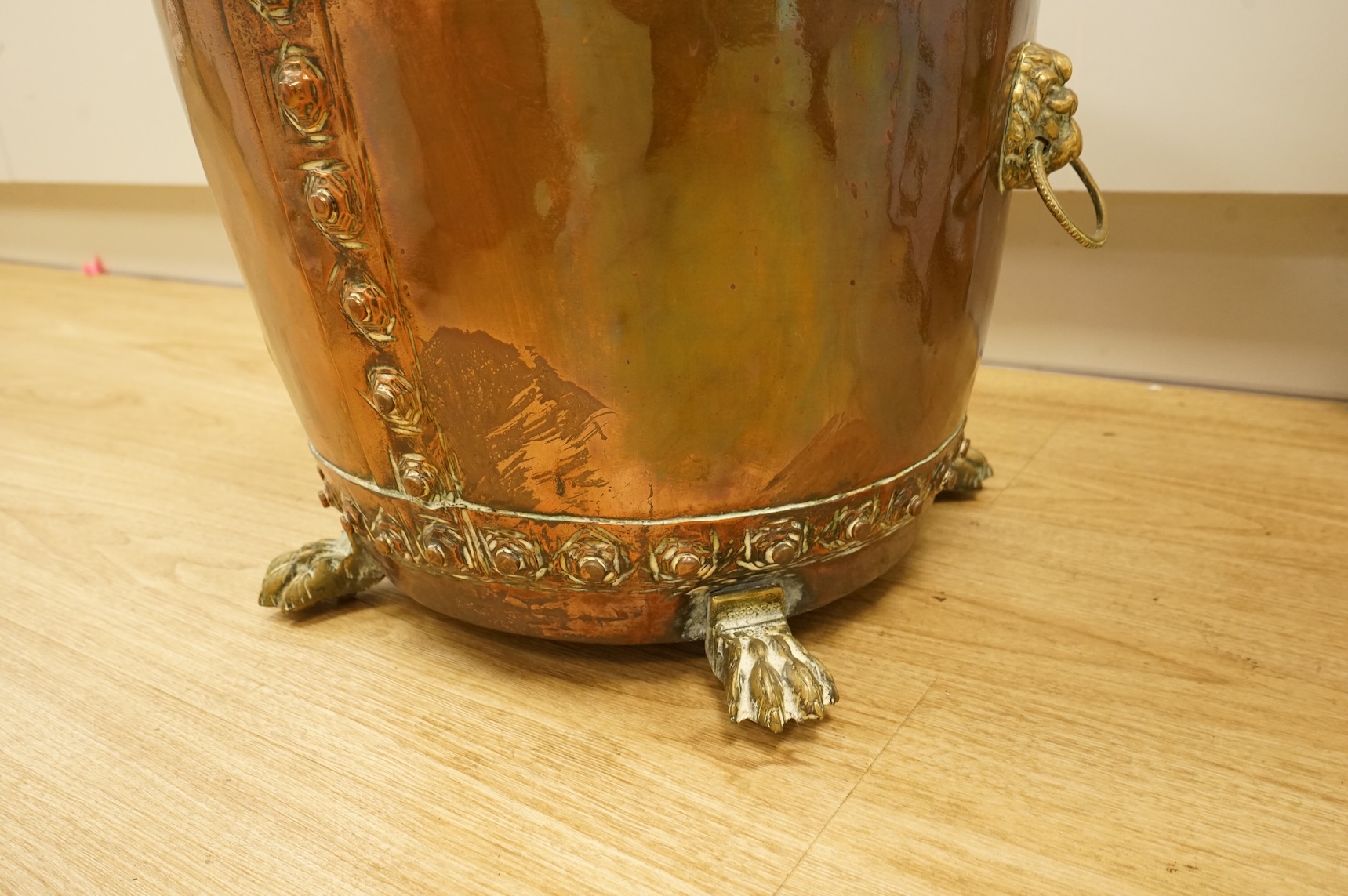 A copper log bucket with paw feet and lion-mask handles, 43cm in diameter